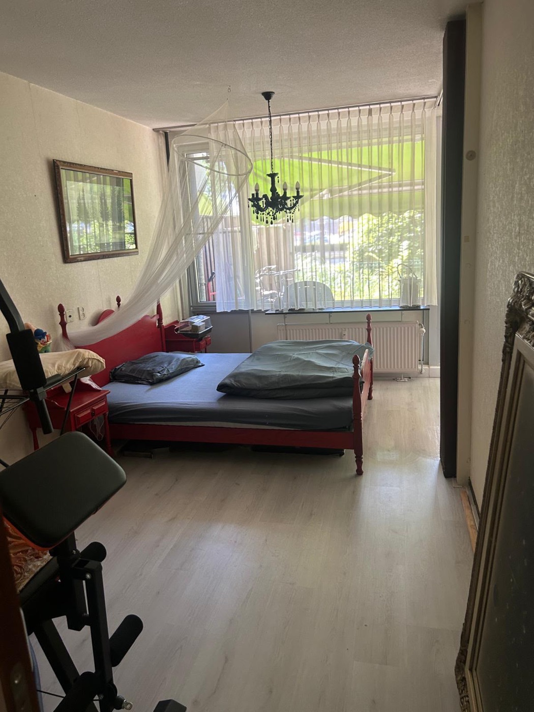 Dezelfde slaapkamer na de schoonmaak, opgemaakt bed en een schone vloer